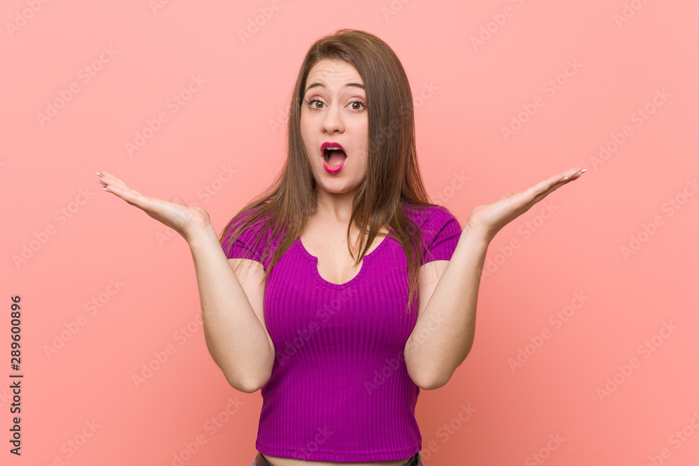 Young hispanic woman against a pink wall surprised and shocked. Young hispanic woman against a pink wall surprised and shocked.