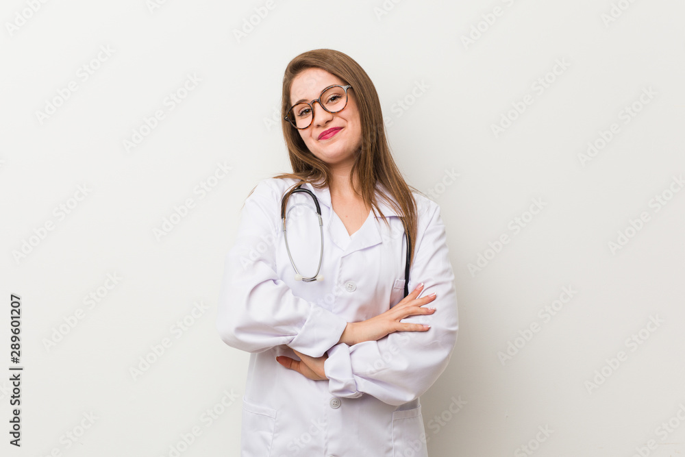 Young doctor woman against a white wall laughing and having fun. Young doctor woman against a white wall laughing and having fun.