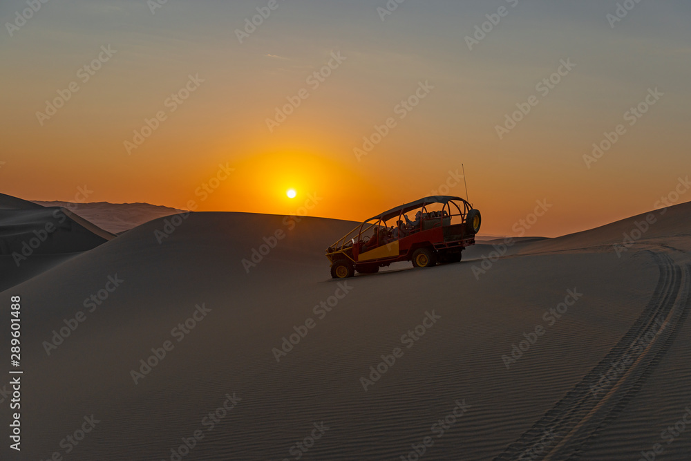 Silhouette of a buggy at sunset in the coastal Peruvian desert between Ica and Huacachina, Peru.