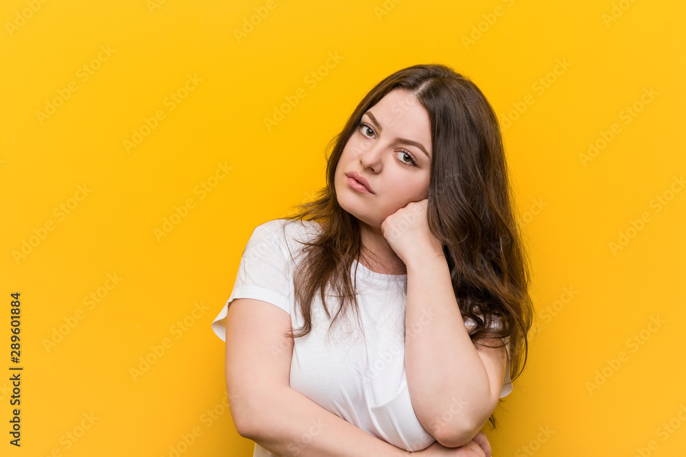 Fototapeta premium Young curvy plus size woman who feels sad and pensive, looking at copy space.