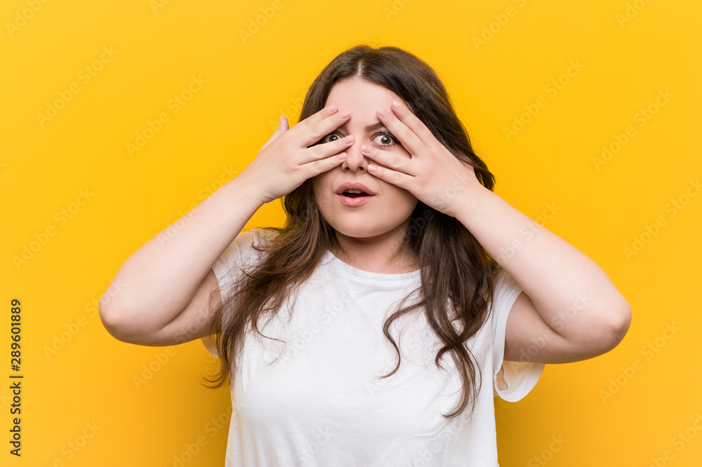 Young curvy plus size woman blink through fingers frightened and nervous. Young curvy plus size woman blink through fingers frightened and nervous.
