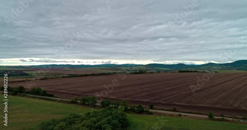 Drone view of the North Hungarian landscape of the Muzsla, part of Matra. Hills and fields of agricultural view with roads in the distance view.  Cloudy view after rain with fog in the forest. photo