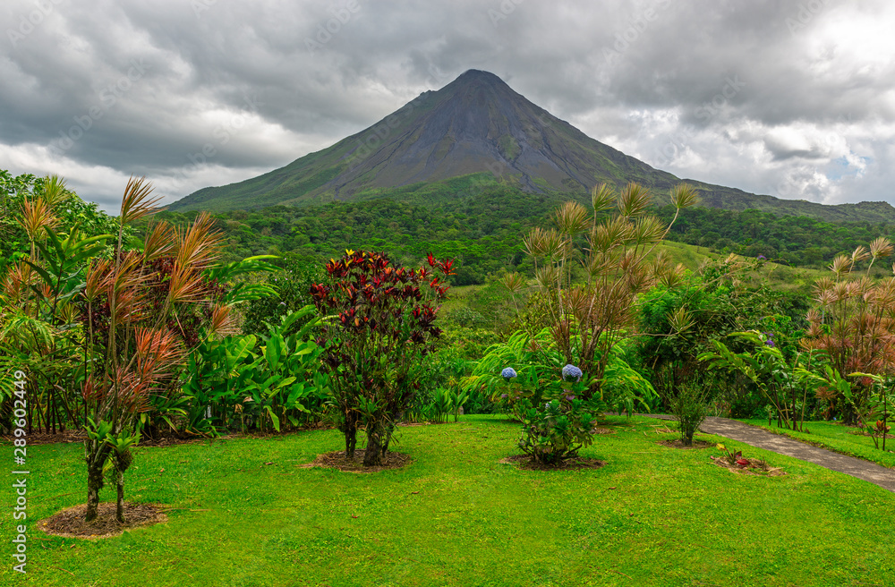 The majestic Arenal volcano with a dramatic sky and an ornamental 