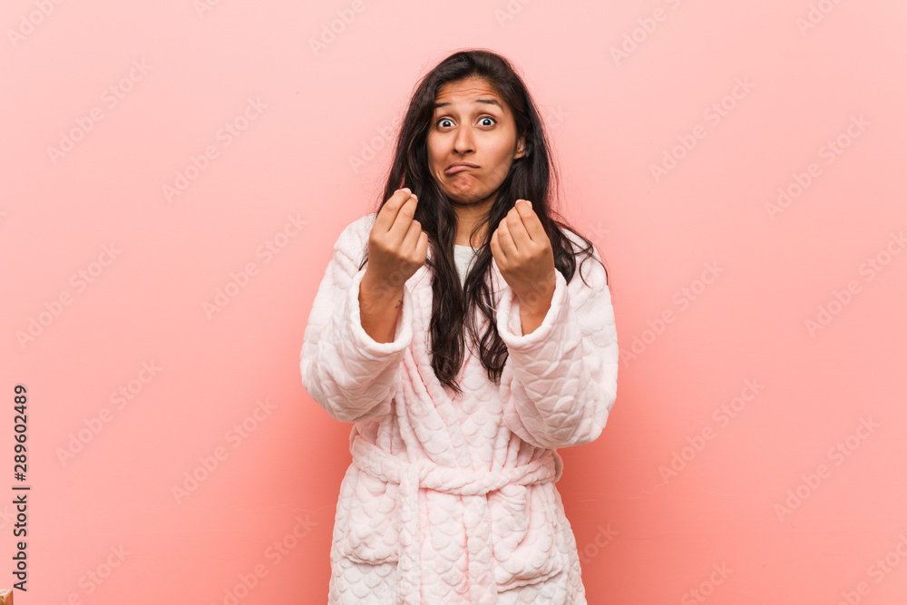 Young indian woman wearing pajama showing that he has no money. Young indian woman wearing pajama showing that he has no money.