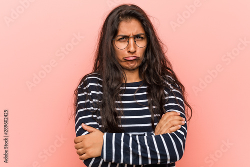 Young intellectual indian woman frowning face in displeasure, keeps arms folded.