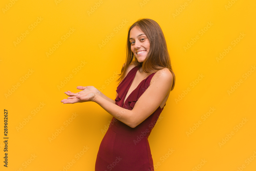 Young elegant woman wearing a dress holding something with hands Young elegant woman wearing a dress holding something with hands
