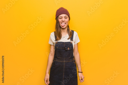 Young hipster woman funnny and friendly showing tongue © Asier