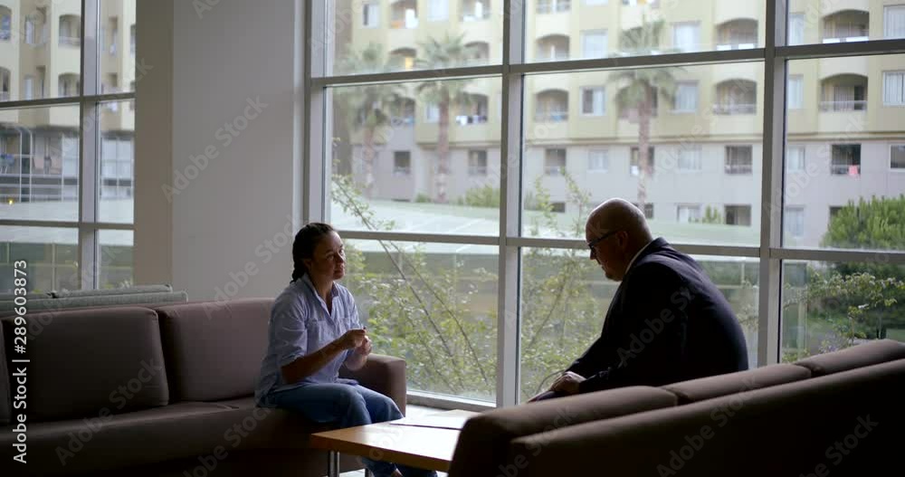 man and woman are having business meeting in hall of office building, woman is signing agreement man and woman are having business meeting in hall of office building, woman is signing agreement