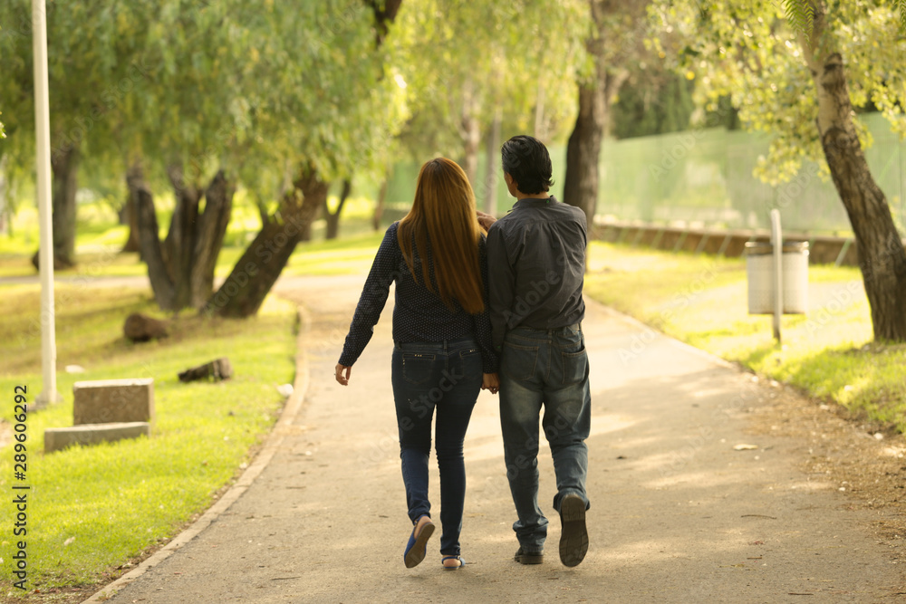 Obraz premium couple in love in park, smiling and friendly, walking, kissing
