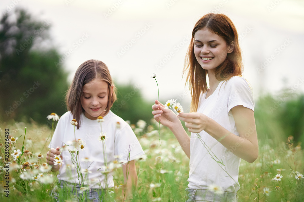 mother and daughter blowing soap bubbles in the park mother and daughter blowing soap bubbles in the park