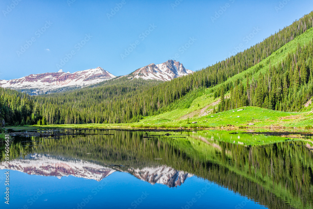Valley with vibrant summer Snowmass creek blue color water pond reflection on Snowmass Lake hike trail in Colorado in National Forest park