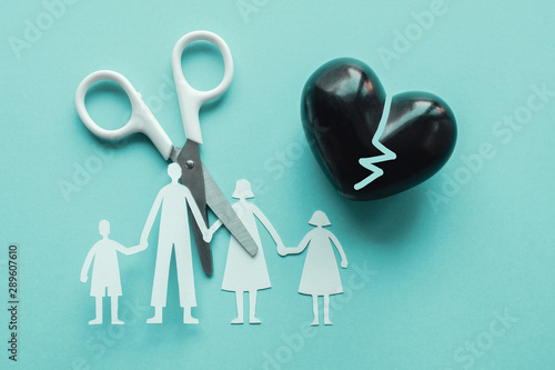 scissor cutting family paper cut out on blue background, causes and effects on child development and behavior of dysfunctional family, divorce broken home concept, mental health photo