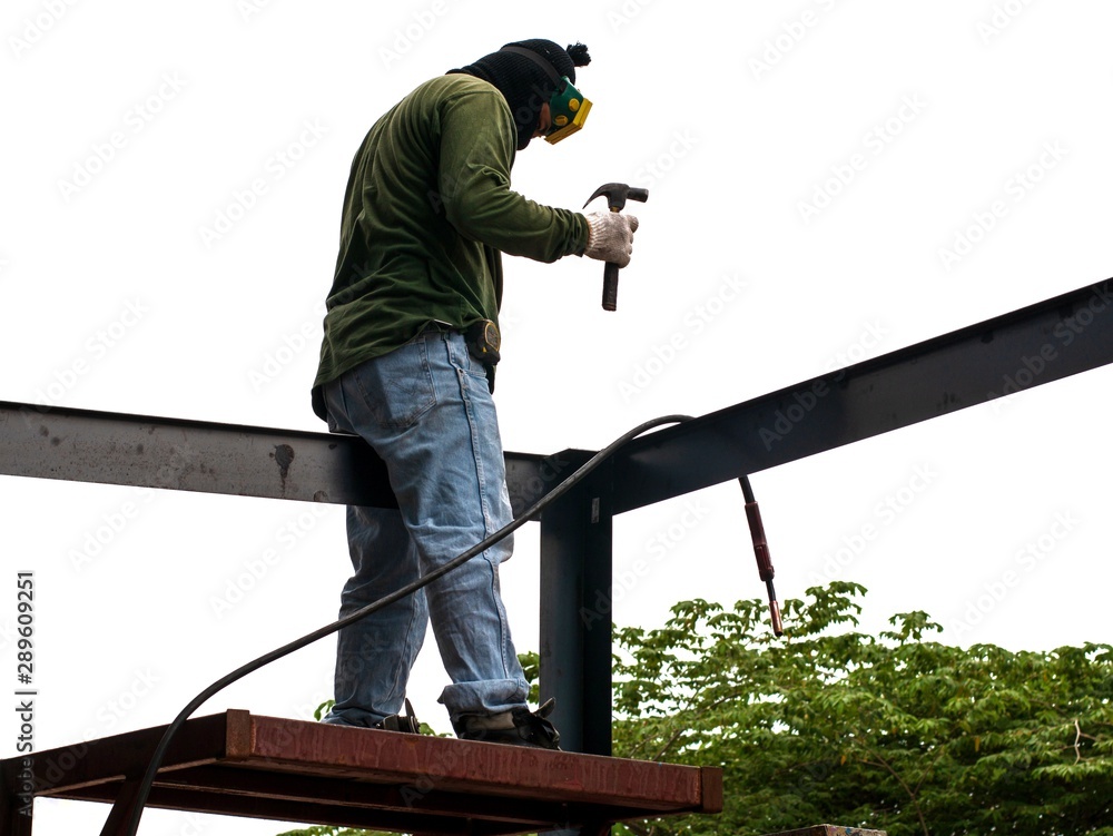 Worker is weld metal with a arc welding machine at the construction site on white background. Industrial steel welder in factory technical. welder Industrial in factory Worker is weld metal with a arc welding machine at the construction site on white background. Industrial steel welder in factory technical. welder Industrial in factory