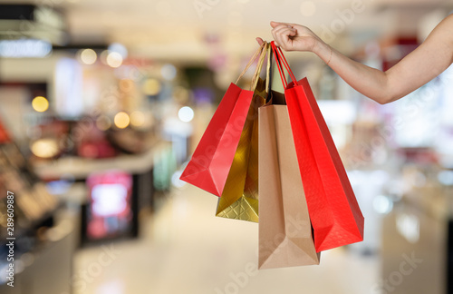 Happy pretty girl holding shopping bags in the shopping mall blurred background, E-commerce digital marketing lifestyle concept