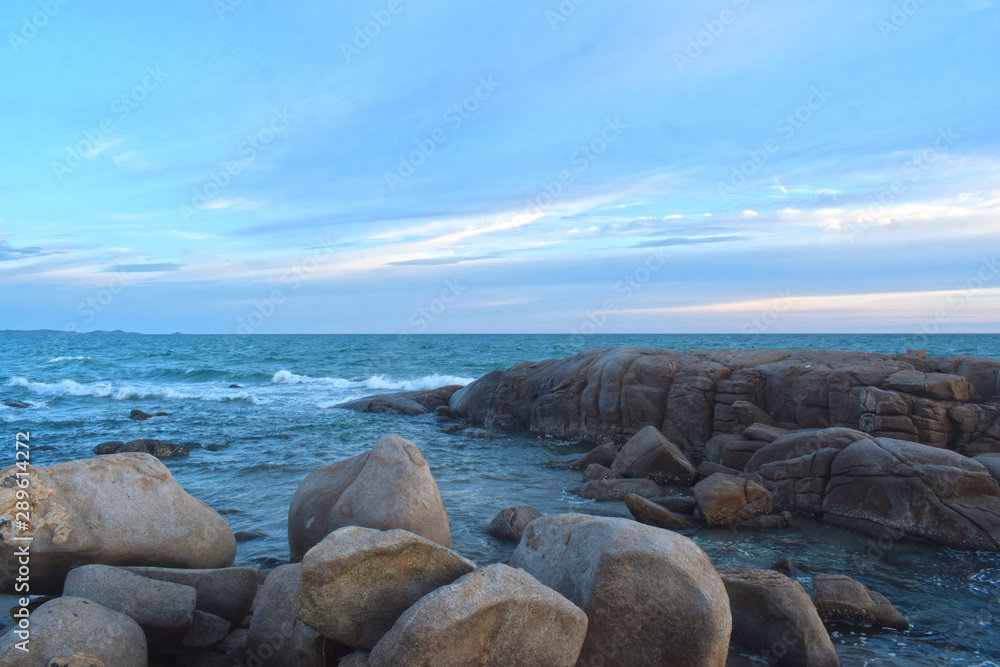 At the beach During the setting sun The wind blows cool. Beautiful clouds and rocks with sandy ground At the beach During the setting sun The wind blows cool. Beautiful clouds and rocks with sandy ground