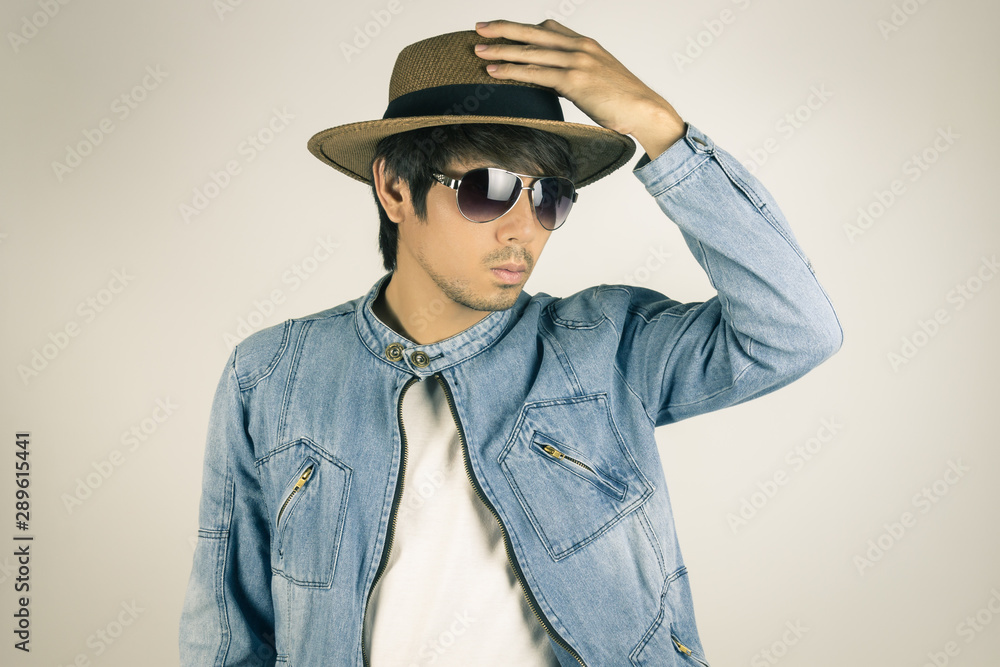 Young Asian Man in Jeans or Denim Jacket Wear Sunglasses and Touch Hat in Vintage Tone Young Asian Man in Jeans or Denim Jacket Wear Sunglasses and Touch Hat in Vintage Tone