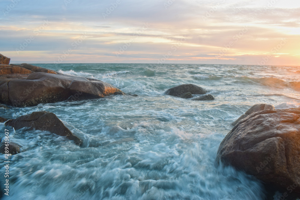 Obraz premium At the beach During the setting sun The wind blows cool. Beautiful clouds and rocks with sandy ground