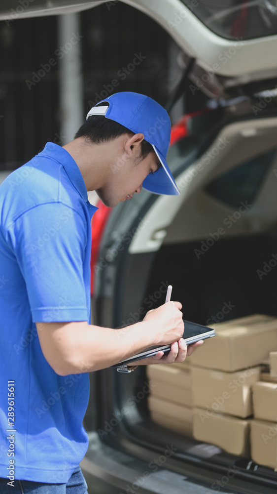 Young delivery man checking the products to customer while standing right next to his car Young delivery man checking the products to customer while standing right next to his car