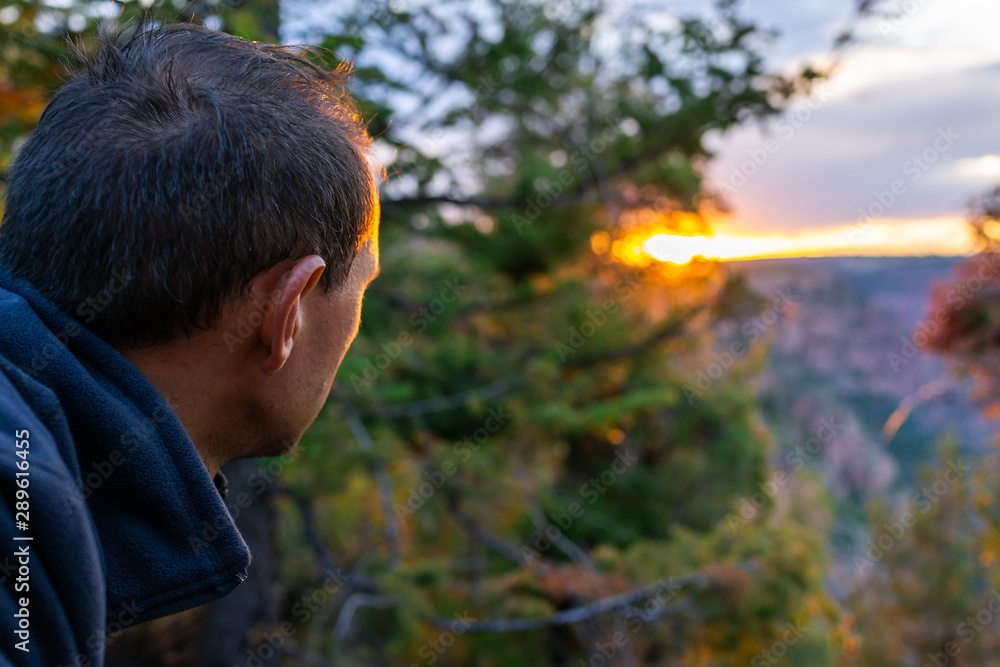 Man looking at view of sunset from Canyon Rim Campground in Flaming Gorge Utah National Park of Green River overlook in dark evening Man looking at view of sunset from Canyon Rim Campground in Flaming Gorge Utah National Park of Green River overlook in dark evening