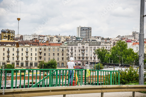 Close up Belgrade panorama taken from the old steel bridge on waterfront, displaying the construction worker planning a new building development and creating new city landmark during summer
