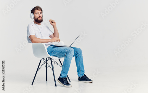 young man sitting on chair and working on laptop