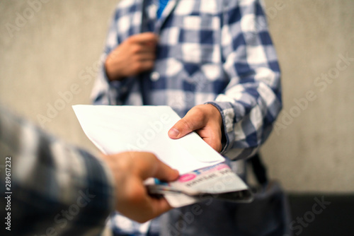 young postman deliver the newspaper envelope and documents at home