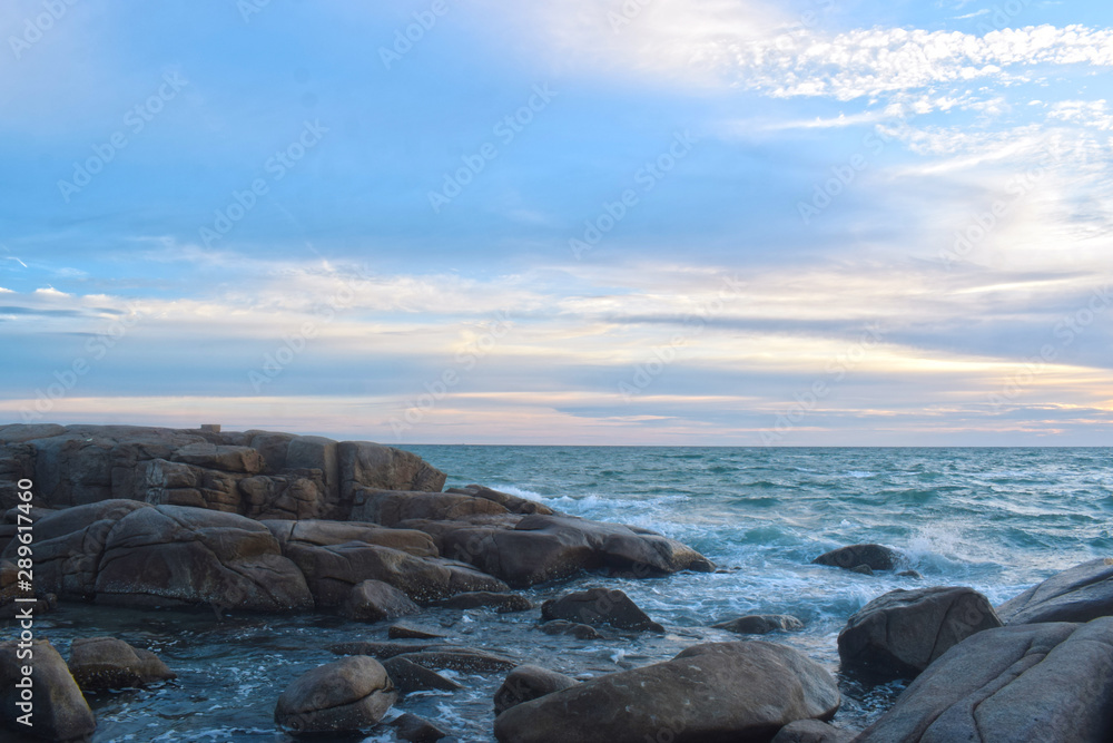 At the beach During the setting sun The wind blows cool. Beautiful clouds and rocks with sandy ground At the beach During the setting sun The wind blows cool. Beautiful clouds and rocks with sandy ground
