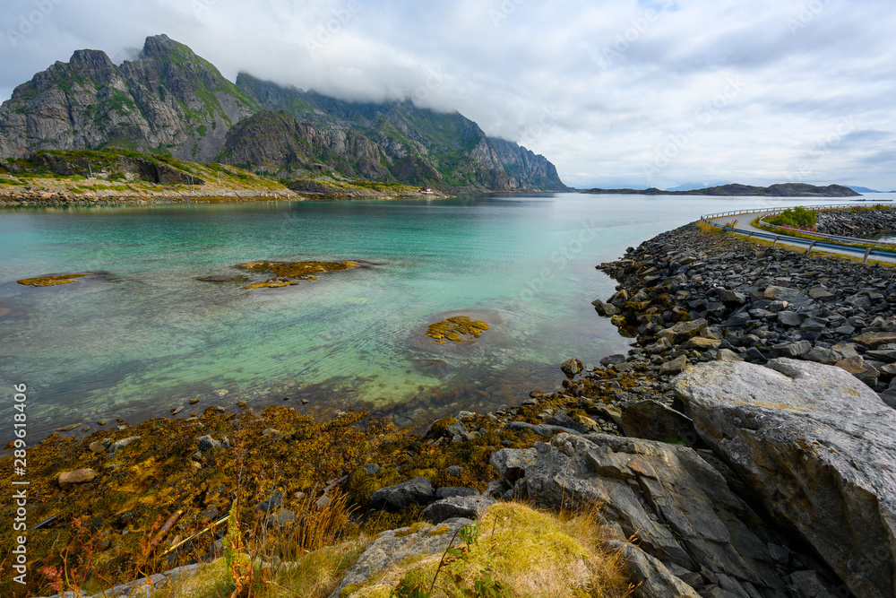 Viewpoint close to Henningsvaer, mountains, sea and rocks during the cloudy season in summer at the Lofoten Islands in Henningsvær, northern Norway