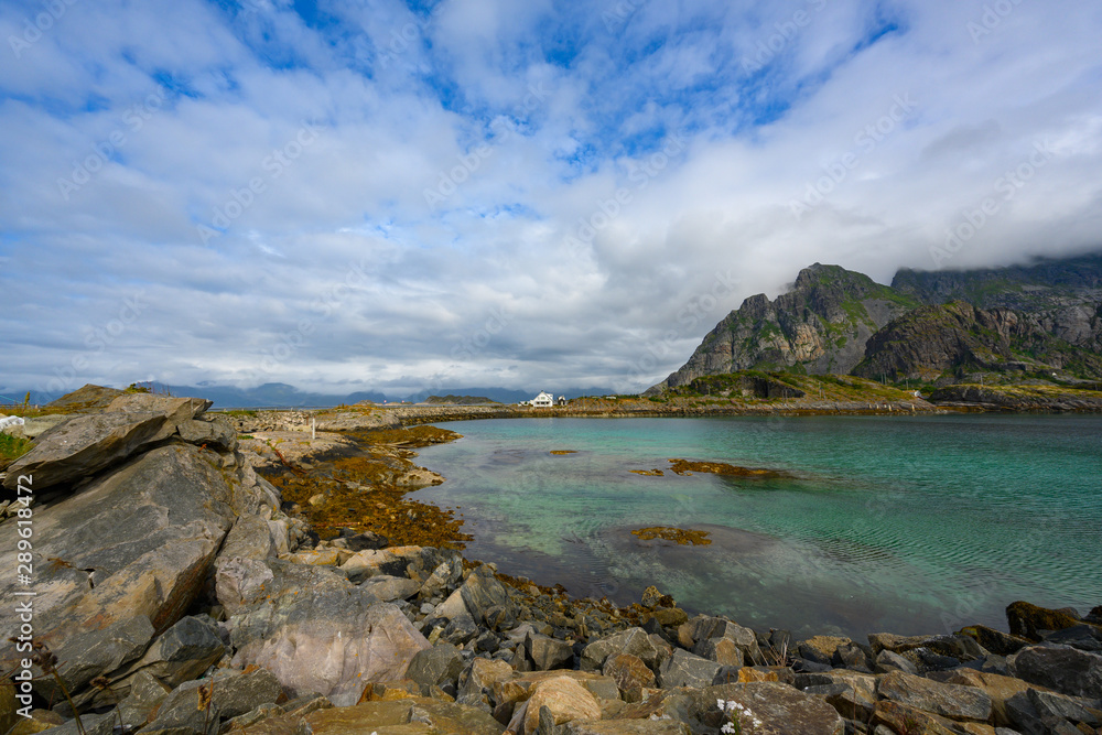 Viewpoint close to Henningsvaer, mountains, sea and rocks during the cloudy season in summer at the Lofoten Islands in Henningsvær, northern Norway