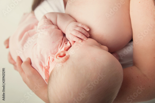 Breastfeeding baby held by mother