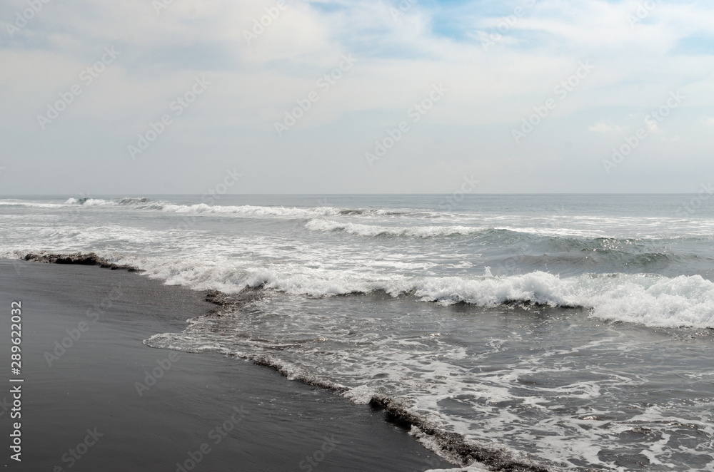 Waves breaking on black sand beach Waves breaking on black sand beach