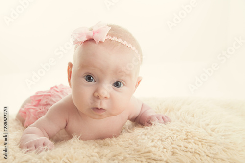 Baby girl doing tummy time holding head up - copy or negatispace