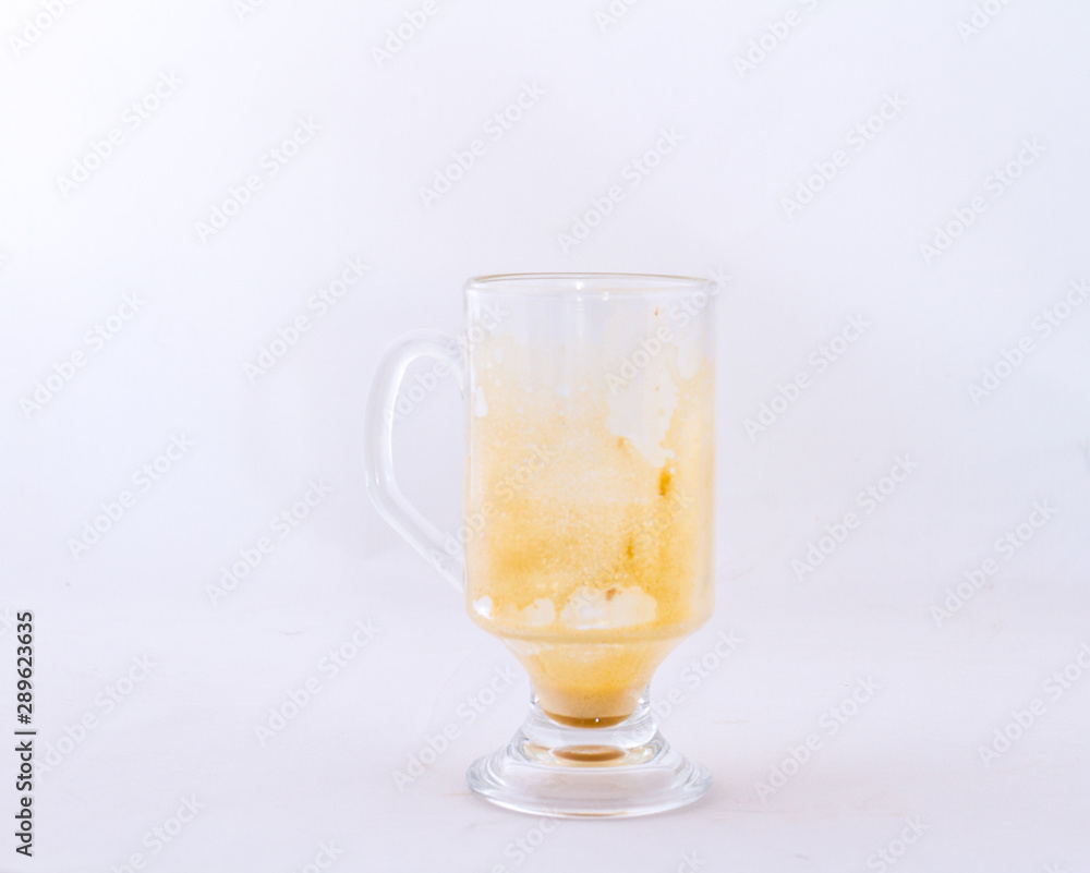 A used transparent glass coffee mug isolated on a white background image with copy space in horizontal format A used transparent glass coffee mug isolated on a white background image with copy space in horizontal format