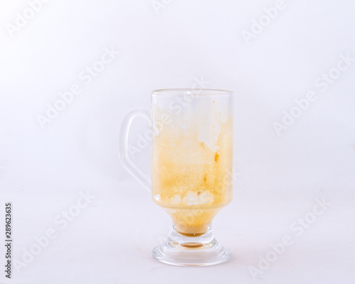 A used transparent glass coffee mug isolated on a white background image with copy space in horizontal format