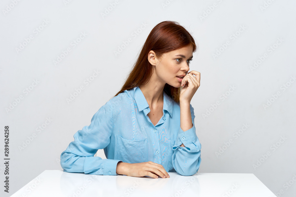 young woman sitting at desk and talking on phone