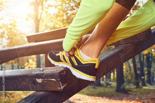 Preparing for jogging in autumn colored park.