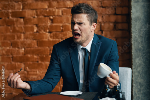 man sitting in a cafe with cup of coffee