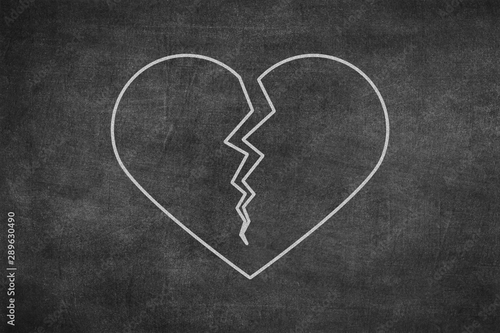 White chalk hand drawing in broken heart shape on blackboard White chalk hand drawing in broken heart shape on blackboard