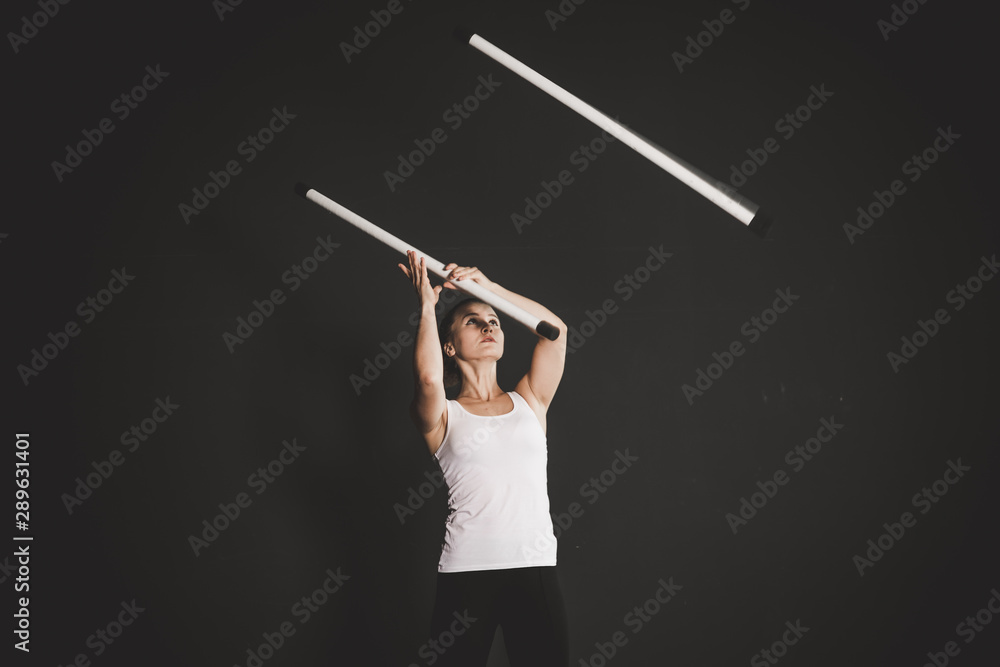 Strong jongler girl training, black background Strong jongler girl training, black background