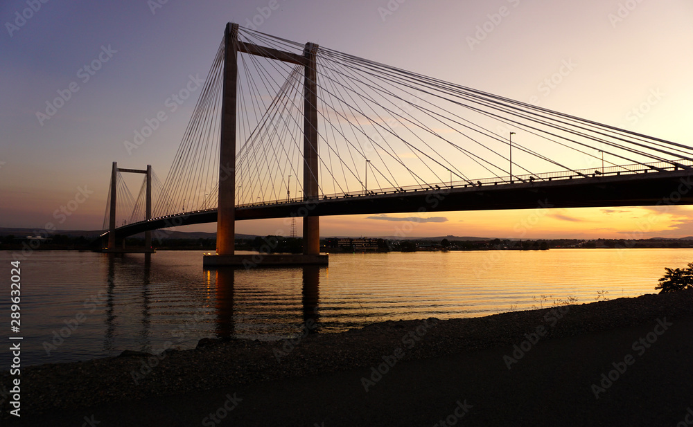 Obraz premium Cable-stayed bridge over river at sunset