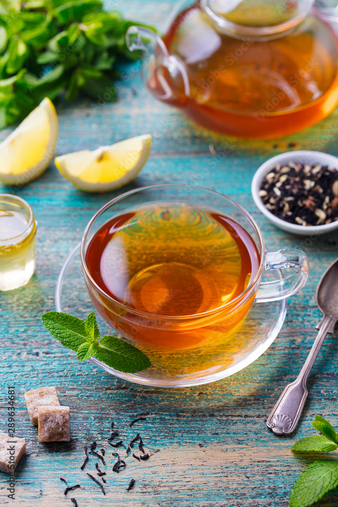Tea cup with mint leaf and lemon. Wooden background. Tea cup with mint leaf and lemon. Wooden background.