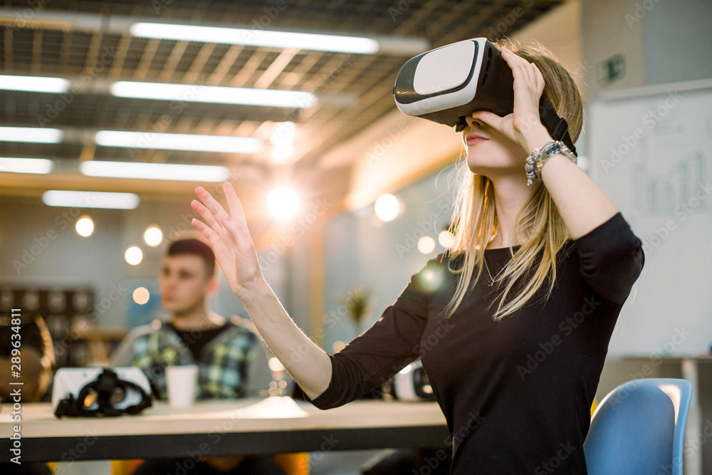 Creative business team using virtual reality glasses at the office. Young  girl wearing 3d vr headset, her colleagues sitting at the table. Teamwork,  startup, innovation concept foto de Stock | Adobe Stock