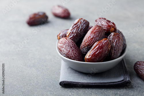 Fresh medjool dates in bowl. Grey background. Copy space. photo