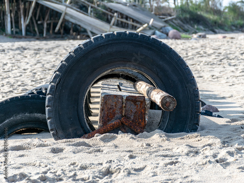 view of the sandy beach by the Baltic Sea. Seashore with old car tires and concrete, human waste, Curonian Spit, Russia