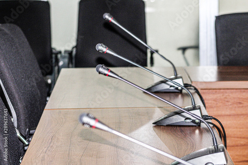 Mini microphones  on the table and chairs black in color  at side
