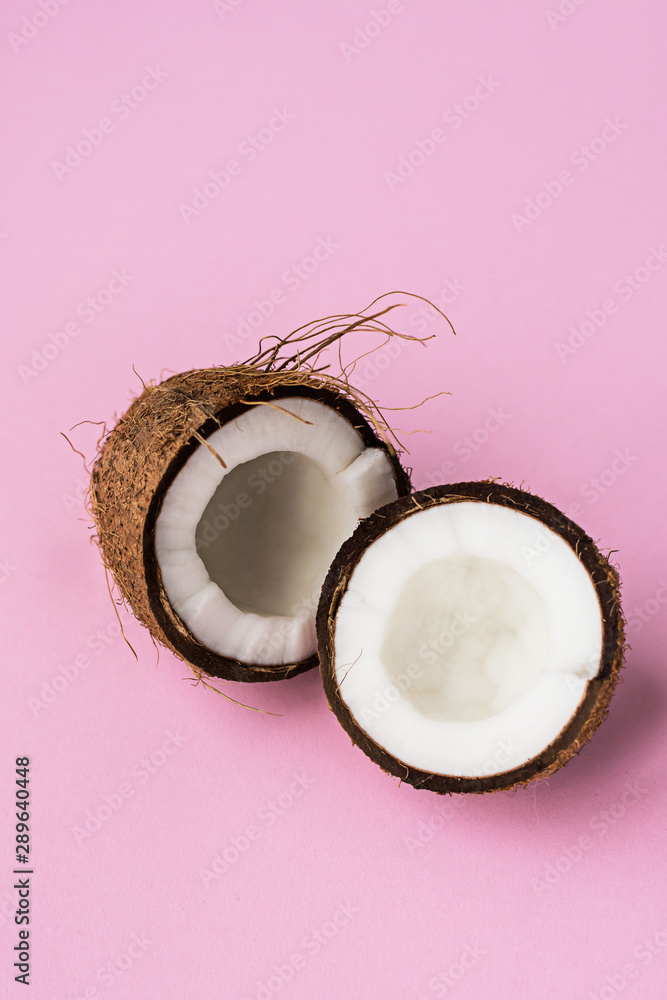 Coconut. Broken coconut on pink background.Two coconut halves. Copyspace Coconut. Broken coconut on pink background.Two coconut halves. Copyspace