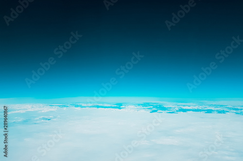 Low earth orbit - turquoise green space and white clouds