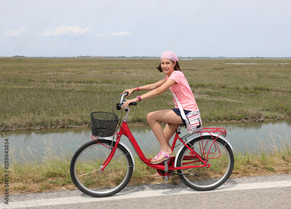 Pretty little girl with bandana on the bike