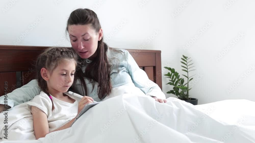 Child and a mother in bed drawing with tablet PC Child and a mother in bed drawing with tablet PC