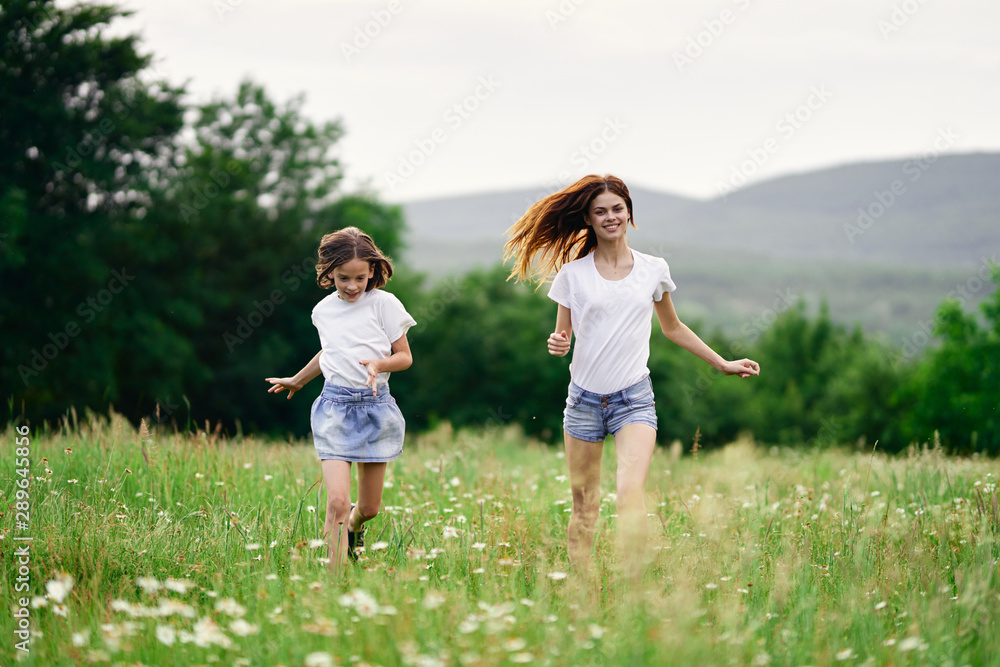 mother and daughter running in the field mother and daughter running in the field